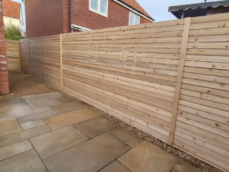 A residential garden with a new, complete larch fencing solution